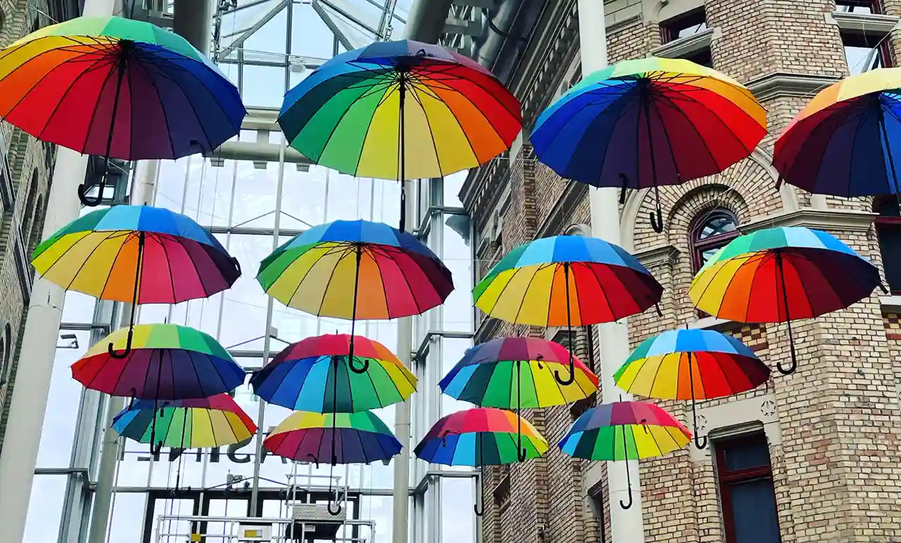 En konstinstallation med färgglada paraplyer upphängda i taket.