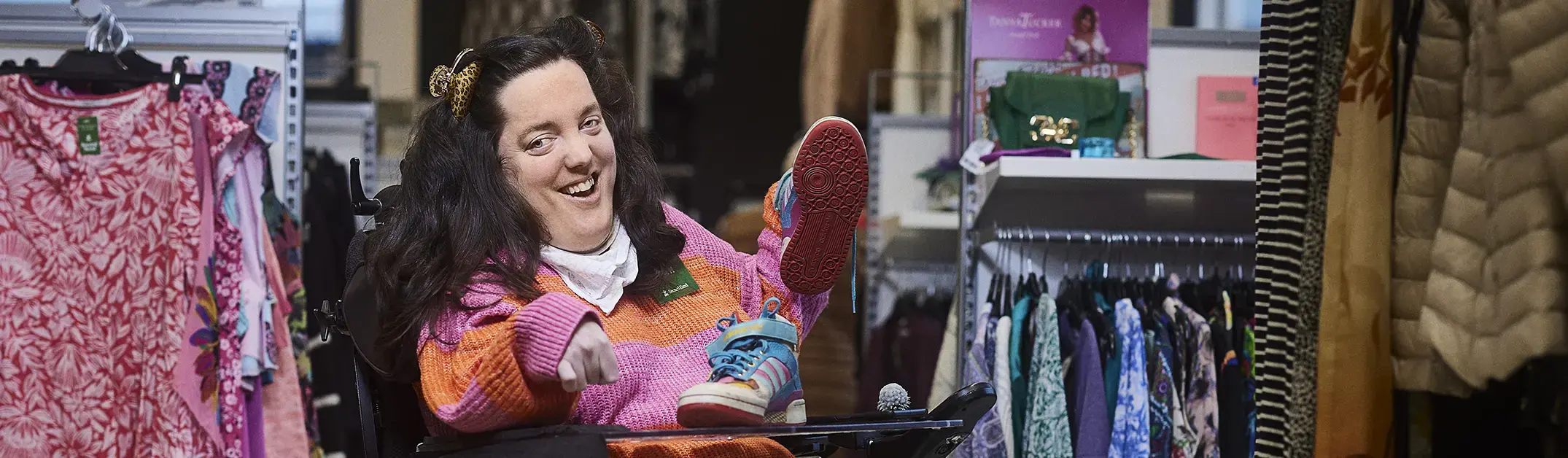 En kvinna med funktionsnedsättning jobbar i en klädaffär.