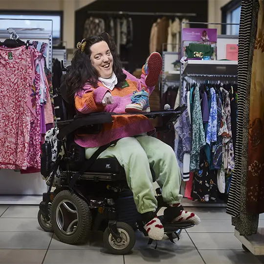 En kvinna med funktionsnedsättning jobbar i en klädaffär.